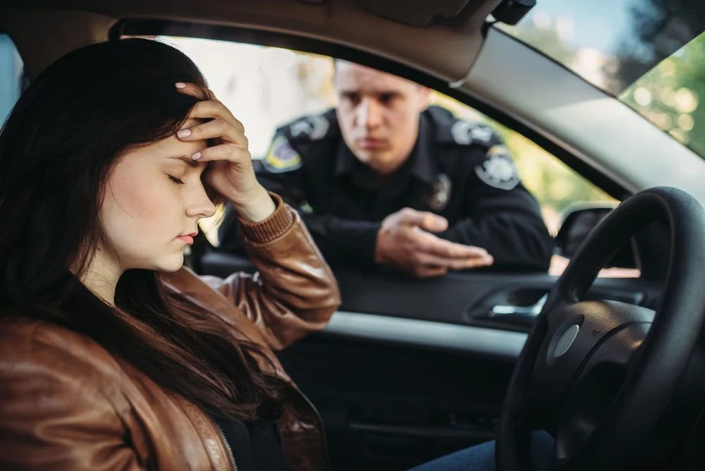 Mujer en carro angustiada con policía que le habla en la ventana