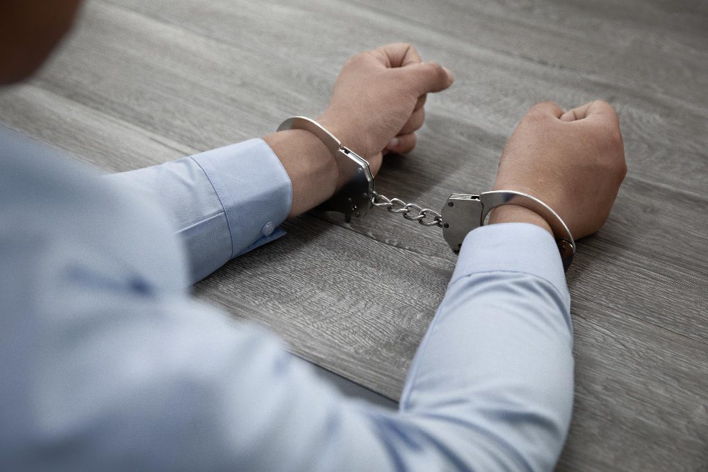 Hombres con esposas siendo acusado de malversación de fondos